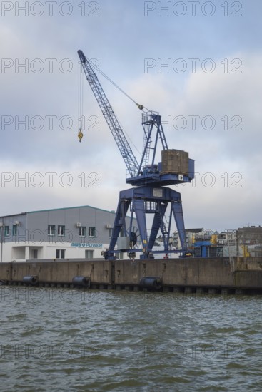 View of a crane standing directly at a harbor basin, Bremerhaven, Bremen, Germany