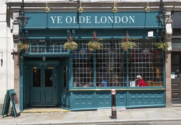 Traditional London pub Ye Old London with green façade and hanging flowers, London, England, Great Britain