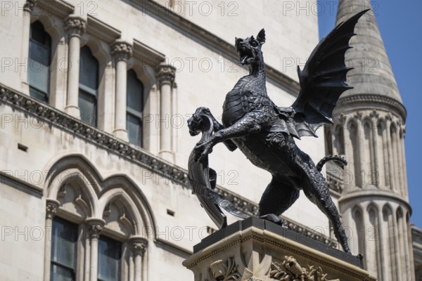 Metal statue of a winged dragon in front of the neo-Gothic building of the Royal Court of Justice, London, England, Great Britain