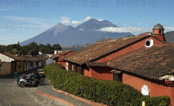 Traditional houses in a cobblestone alley with the Fuego volcano in the back, Old Town, Antigua, Highlands, Sacatepéquez Department, Guatemala