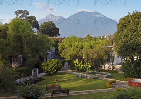 Garden of the Hotel Villa Colonial in the old town, the smoking volcano Fuego in the back, Antigua, Highlands, Sacatepéquez Department, Guatemala