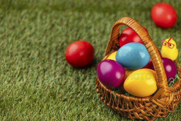 A basket full of colorful Easter eggs on a grassy area