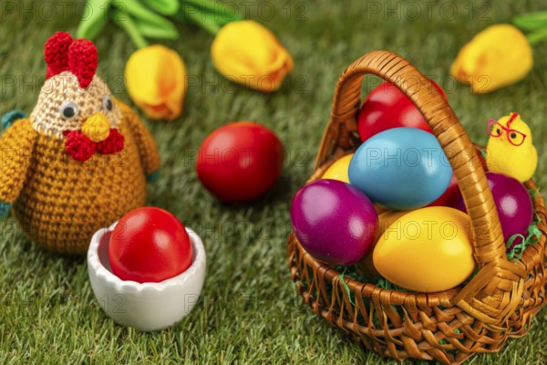 A basket of colorful Easter eggs next to a chicken figurine