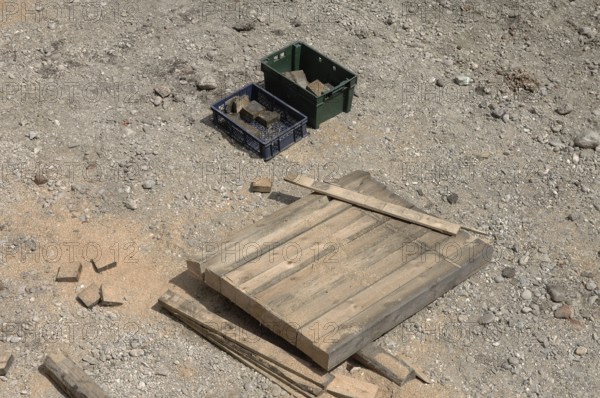 Wooden beams and 2 boxes on a construction site