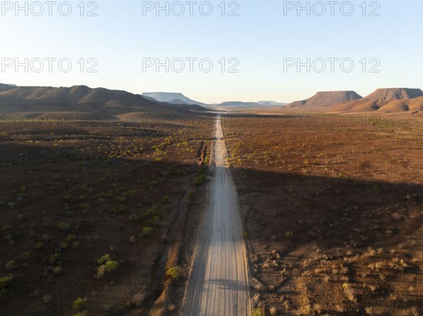 Aerial view, infinite space, straight road leads through dry desert landscape, hills in Damaraland, Namibia