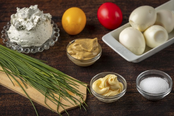 Fresh ingredients, such as herbs, cream cheese and eggs on a wooden table