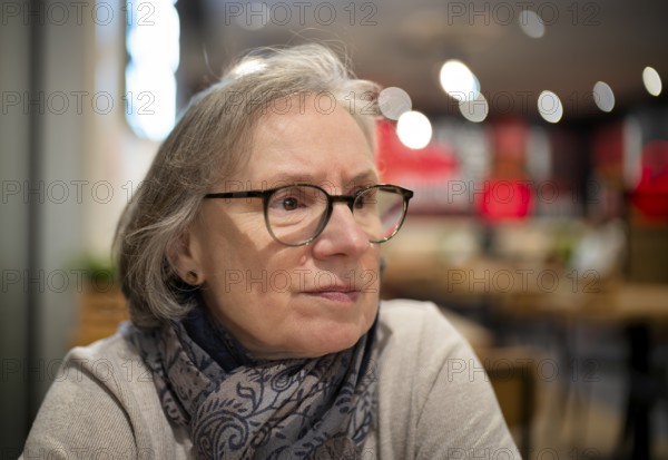 Elderly woman, portrait, glasses, gray hair, scarf, sitting in a bar, restaurant, Stuttgart, Baden-Württemberg, Germany