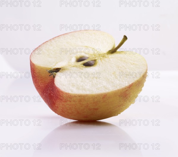 Half of an apple (Malus domestica) in front of a white background, studio shot