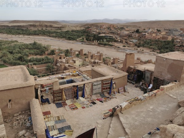 Carpet market on a hill overlooking an oasis and surrounding buildings, Morocco