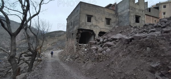 Dilapidated, collapsed buildings following an earthquake in the Atlas Mountains, on a lonely, barren road, Morocco