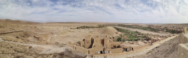 Historic buildings and an oasis in desert-like surroundings under cloudy skies, Morocco