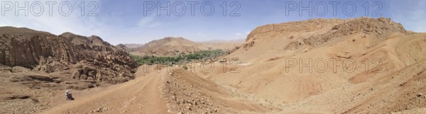 Extensive desert landscape with mountains and a small green oasis, Morocco
