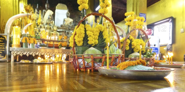 Sacrifices with candles, in front of numerous Buddhas and the City Pillar, which is considered the home of the city's protective spirit, Wat Si Muang temple complex, Vientiane, Laos