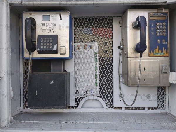 Two retro-designed telephone booths in an urban setting with metal grille and shades of gray, Casablanca, Morocco