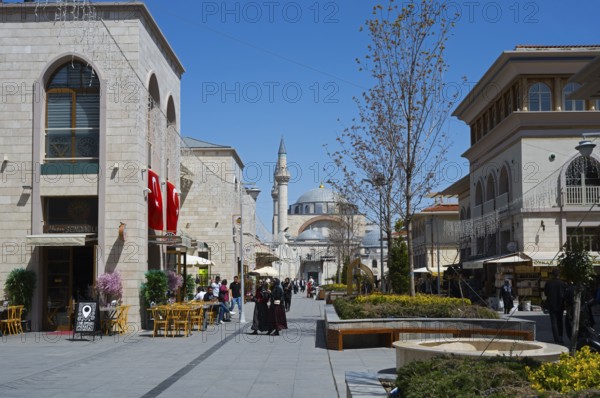 Lively shopping street with stylish buildings, mosque in the background and decorative lighting, mosque, Konya Sultan Selim Camii, Konya, Central Anatolia, Turkey