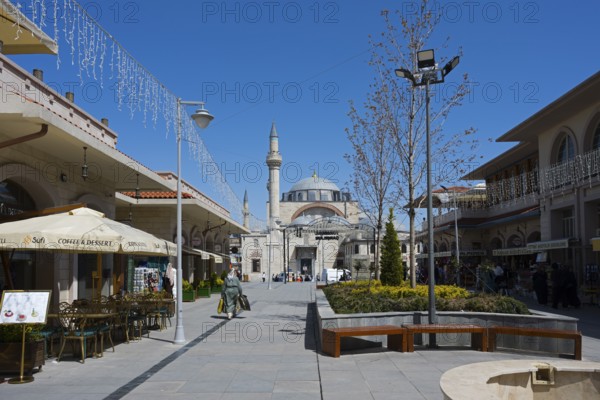 Wide pedestrian zone with shops and street cafés, a mosque in the background under a blue sky, mosque, Konya Sultan Selim Camii, Konya, Central Anatolia, Turkey