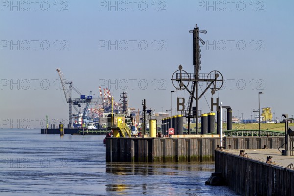 Industrial port with cranes and calm water under a blue sky, The City of Bremen