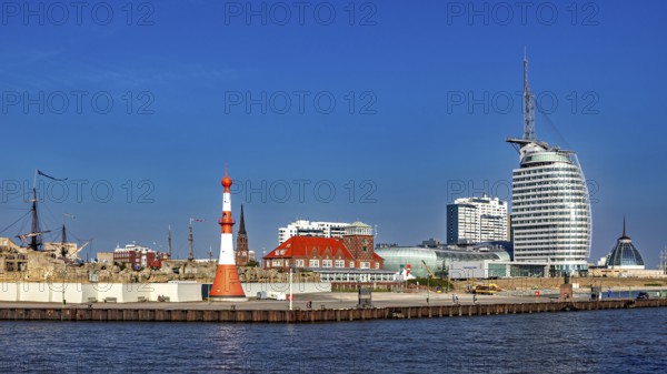 Lighthouse and modern buildings at the harbor under clear skies, The City of Bremen