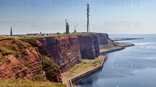 Red cliffs with lighthouse under blue sky on the coast, the high-seas island of Heligoland in the North Sea