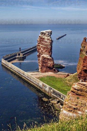 High rock by the sea with a protective wall, the high-seas island of Heligoland in the North Sea
