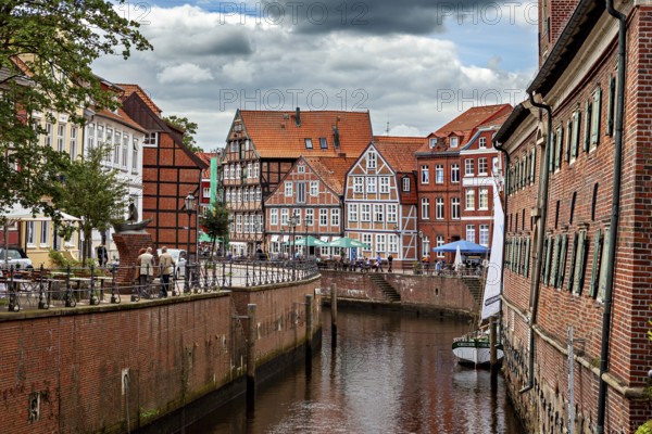 Boats on the river surrounded by half-timbered houses with brick walls under a cloudy sky, The old town of Stade