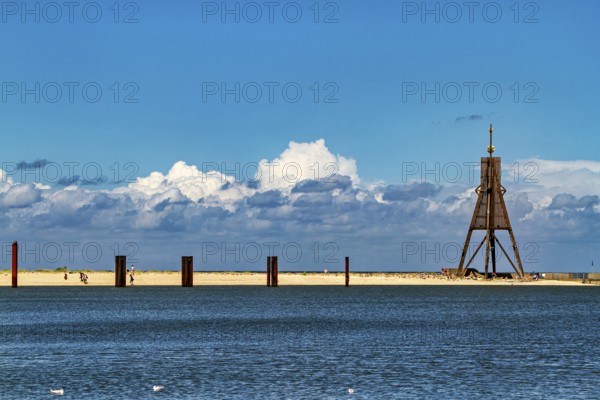 A quiet beach on the North Sea with blue skies, clouds and a lighthouse, Die Kugelbake von Cuxhaven