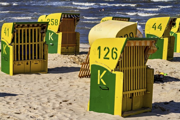 Yellow and green beach chairs stand in the sun on the beach with a view of the sea, beach chairs on the beach in Cuxhaven
