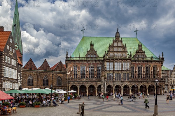 Market square with Renaissance buildings and cafés, people under a dramatic sky, The Town Hall of Bremen