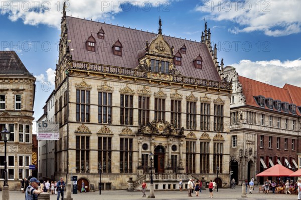 Magnificent Renaissance building with ornate details surrounded by people on a sunny square, The Town Hall of Bremen