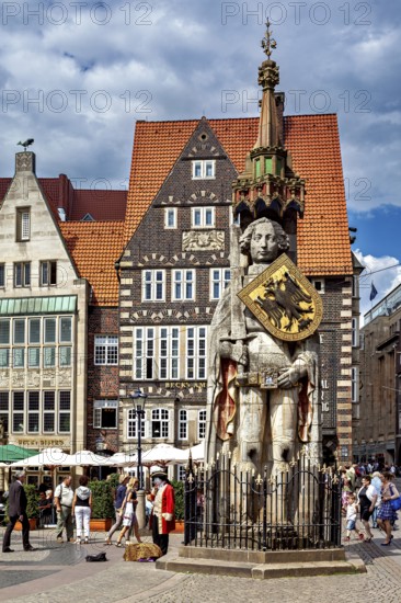 City center scene with the Roland statue in front of impressive half-timbered houses under a blue sky, The Knight Roland on the market square in Bremen