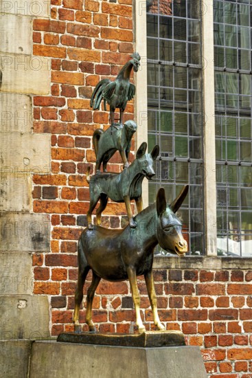 The Town Musicians of Bremen as a bronze sculpture in front of an old wall with windows, The Bremen Town Musicians Memorial in Bremen