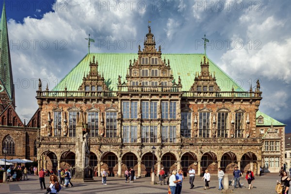 A historic Renaissance-style building on a busy market square in Bremen, under a cloudy sky, The Town Hall of Bremen
