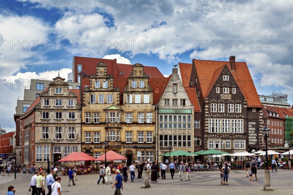 Historic old town with half-timbered houses and people on a busy market square under a blue sky, the center of the Hanseatic City of Bremen