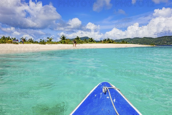 View of blue bow from small tour boat onto turquoise blue-green lagoon in front of uninhabited Caribbean island of Lesser Antilles in the Caribbean, bright secluded sandy beach of sandy beach Island off Carriacou, Carriacou, Grenada