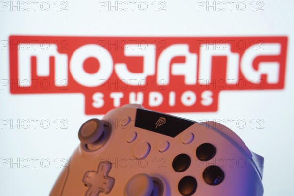 Dhaka, Bangladesh- 20 Mar 2025: A close-up of a white gamepad with the Mojang Studios seen on screen in the background