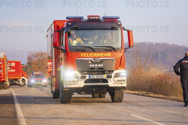 A fire truck drives on a road through a wooded area with emergency personnel, fire brigade exercise at the Hermann Hesse Railway, Ostelsheim, Calw district, Germany