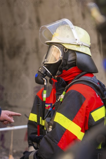 Firefighter with respirator and helmet, focused and ready for rescue measures, fire brigade exercise on the Hermann Hesse Railway, Ostelsheim, Calw district, Germany