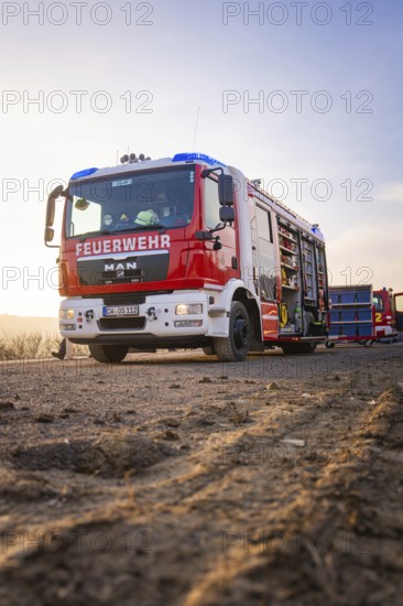 A fire truck stands on a country road in patrol light, firefighters ready to act, fire brigade exercise on the Hermann Hesse Railway, Ostelsheim, Calw district, Germany