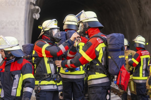 Firefighters in protective clothing deployed in front of a tunnel, focused on communication tasks, fire brigade exercise on the Hermann Hesse Railway, Ostelsheim, Calw district, Germany