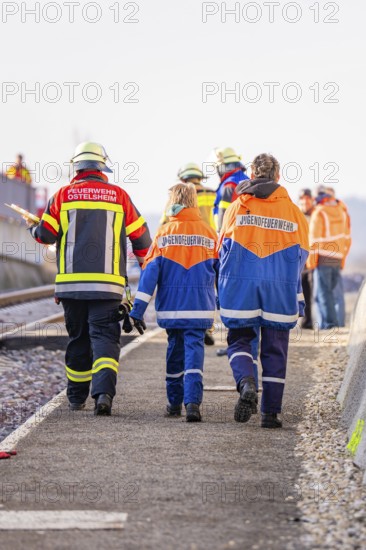 People wearing fire uniforms walk along a railway line, fire brigade exercise at the Hermann Hesse Railway, Ostelsheim, Calw district, Germany
