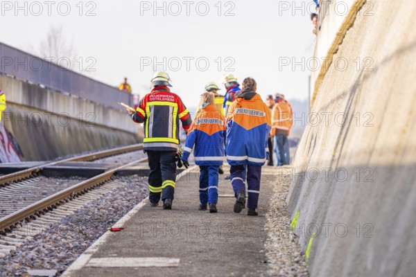 Firefighters in uniforms walk along railroad tracks, sunny background, fire brigade exercise on the Hermann Hesse Railway, Ostelsheim, Calw district, Germany