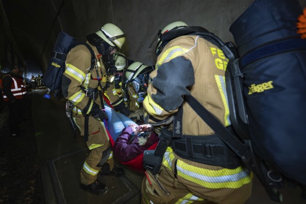 Firefighters rescue an injured person in a tunnel with a stretcher, fire brigade exercise on the Hermann Hesse railway, Ostelsheim, Germany