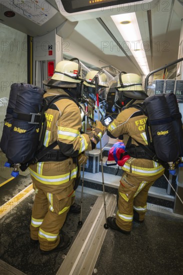 Firefighters wearing brown equipment during a rescue operation on the train, fire brigade exercise on the Hermann Hesse railway, Ostelsheim, Germany