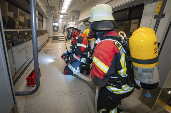Firefighters inspect the interior of a train in full gear, fire brigade exercise on the Hermann Hesse railway, Ostelsheim, Germany