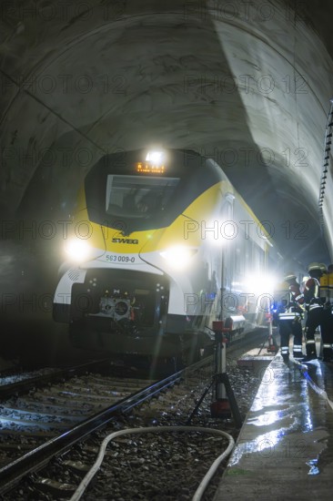 Train crosses an impressively illuminated tunnel with firefighters, fire brigade exercise on the Hermann Hesse railway, Ostelsheim, Germany
