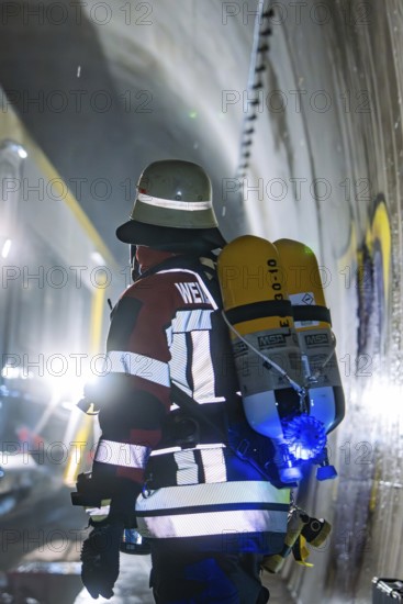 A firefighter with a respirator in an illuminated tunnel during an operation, fire brigade exercise on the Hermann Hesse Railway, Ostelsheim, Germany