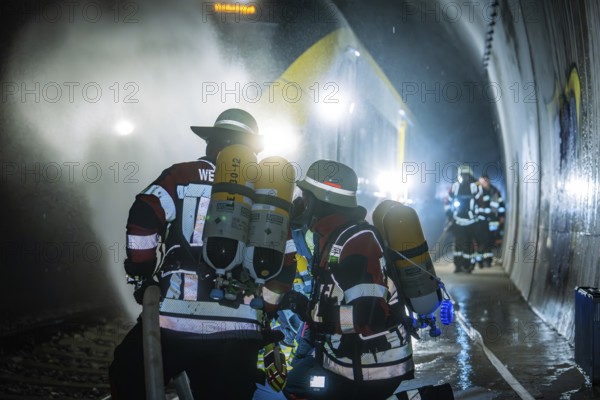 Firefighters working in a gloomy tunnel with respirators, fire brigade exercise on the Hermann Hesse Railway, Ostelsheim, Germany