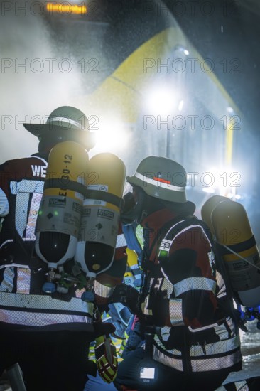 Firefighters wearing respiratory protection in an illuminated tunnel during an operation, fire brigade exercise on the Hermann Hesse railway, Ostelsheim, Germany
