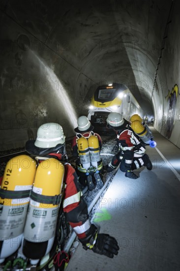 Several firefighters in a tunnel filled with a train, fire brigade exercise on the Hermann Hesse railway, Ostelsheim, Germany