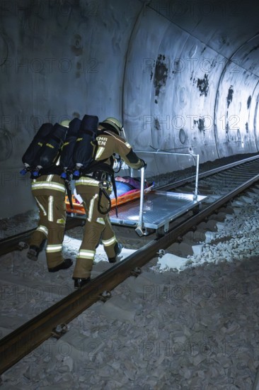 Firefighters push a stretcher on the train tracks in the tunnel, fire department exercise on the Hermann Hesse railway, Ostelsheim, Germany